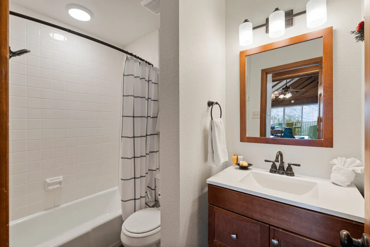 A bright and inviting bathroom with a spacious vanity, modern sink, and a bathtub, complemented by a large mirror. The serene atmosphere encourages relaxation and self-care.