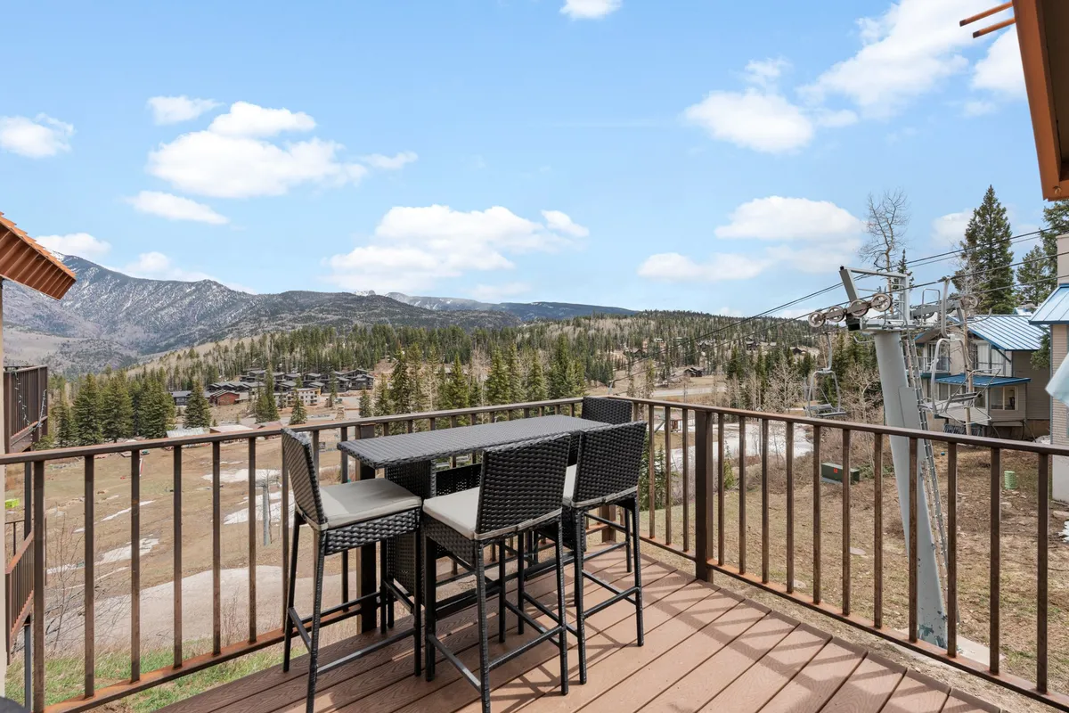 A serene outdoor dining area overlooking a stunning mountain view, with a ski lift visible in the distance. The setting is perfect for après-ski relaxation, morning coffee, or watching the sunset after a day on the slopes.